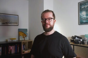Felix Frank, historian and visual researcher, in his study, surrounded by books and camera equipment.